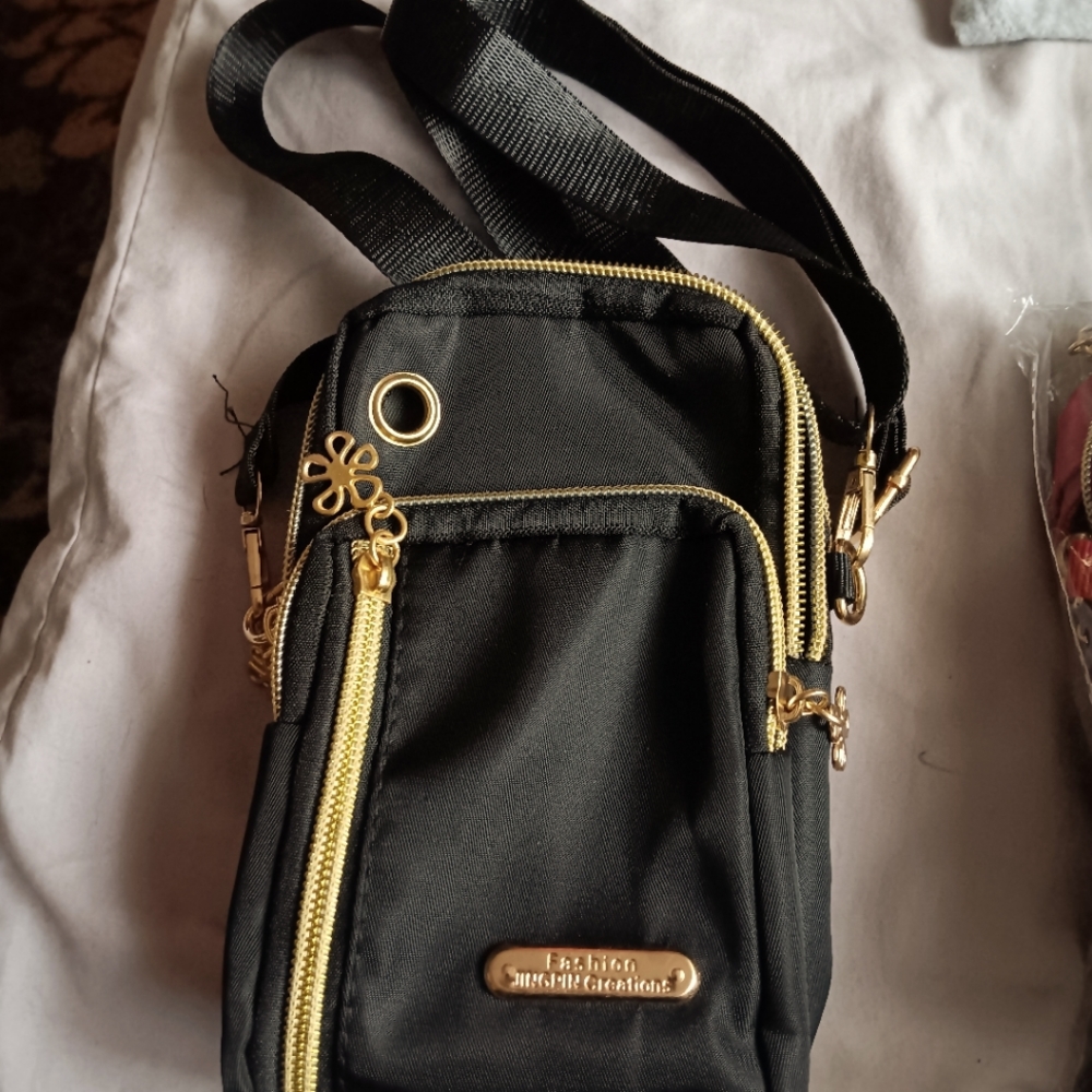 Trendy shoulder / arm bag with multi zipper phone holder. Perfect for travel